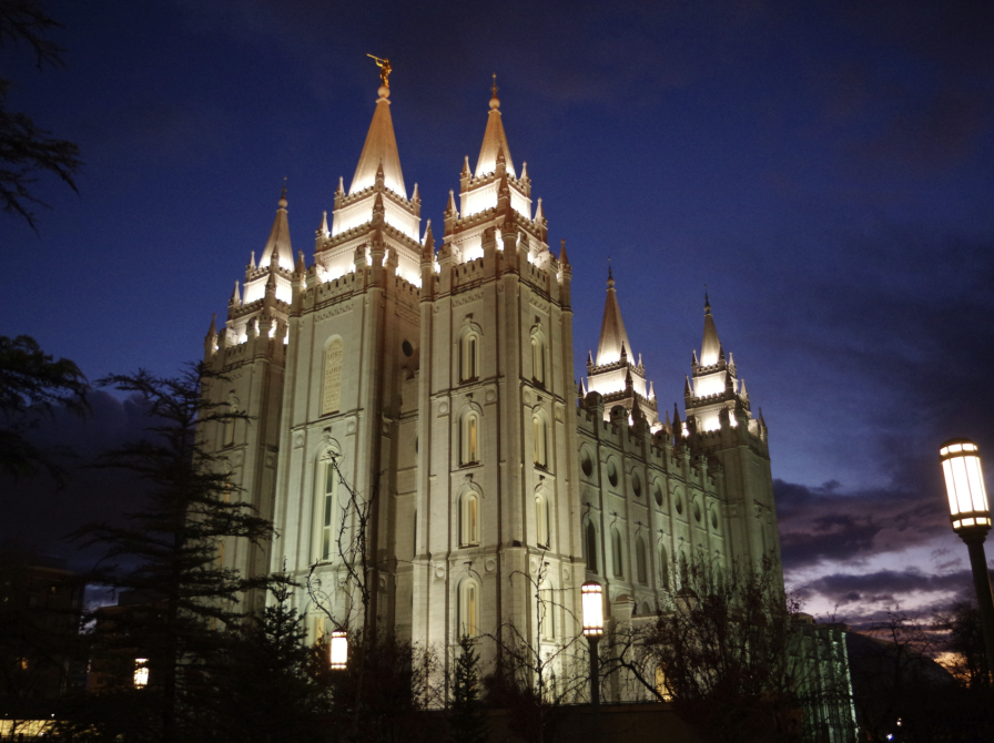 Billeder viser Mormontemplet i Salt Lake City om natten. Templet er lyst op og har fem spir.